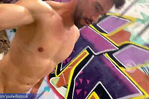 In an abandoned warehouse, an equally daring stud shows off his physique