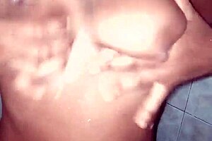 Sexy African-American couple with cell phone enjoys outdoor blowjob in a public restroom stall
