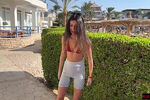Sexual women pee on the sand in her swimming costumes