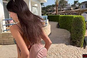 Sexual women pee on the sand in her swimming costumes