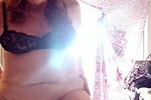 A beautiful brunette with absolutely smooth skin puts on cream on her face