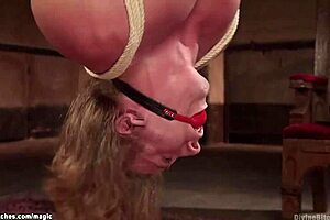 The dominant female spanks a man suspended in the air