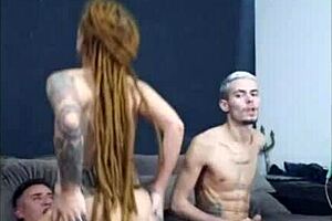 A redheaded woman with dreadlocks sucks a guy and has sex with him and his wife then the wife masturbates another man