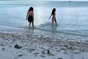 Stepmother and stepdaughter with large bosoms enjoy a golden shower at the beach.
