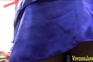 Beautiful Asian woman in pantyhose has her skirt lifted and her panties exposed in public
