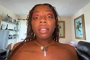 Lucy Hayz has black skin and she is watering her plants in a very sensual way