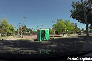 A mature woman enjoys oral sex in public through a glory hole