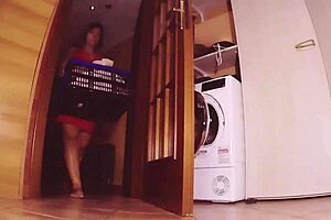 Mature wife puts dirty clothes in the washing machine