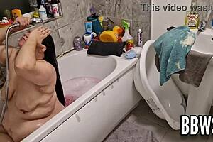 A pervert watches a busty BBW wash her big, pendulous breasts in the bathtub