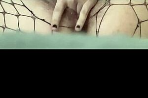 Fingering her pussy through fishnets, the girl reaches orgasm